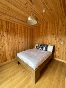 a bedroom with a bed in a wooden room at Southern County Resort in Sheean