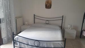 1 dormitorio con 1 cama y reloj en la pared en casa vacanze la pizzica, en Palmariggi