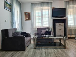 a living room with a couch and a tv at Bed and Breakfast Villa Klaic in Dubrovnik