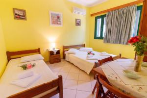 a room with two beds and a table and chairs at Cleopatra rooms in Nikiana