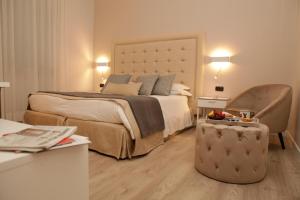 a bedroom with a large bed and a chair at Hotel Villa Ida in Ceprano