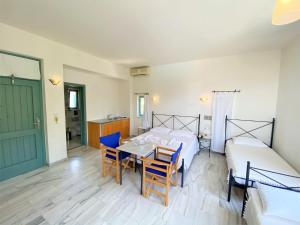 a bedroom with a bed and a table and chairs at Hotel Plakures in Falasarna