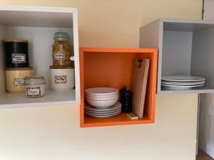 a cupboard with plates and bowls in it at The Buttery in Brundall