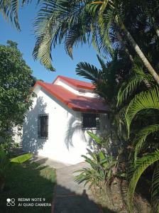 un edificio blanco con techo rojo y palmeras en Casa Monika, en Sosúa
