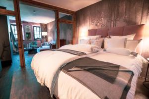 a large bedroom with a large bed with white sheets at LÖFFELMÜHLE BOUTIQUE BED AND BREAKFAST in Pillig