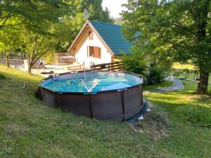 a hot tub in the grass in front of a house at SanMari_forest in Ledenice