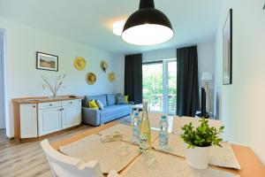 a living room with a table and a blue couch at M&K Apartament Słomkowe Kapelusze - Sobieszewo, Wyspa Sobieszewska in Gdańsk