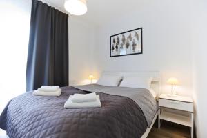 Łóżko lub łóżka w pokoju w obiekcie M&K Apartament Słomkowe Kapelusze - Wyspa Sobieszewska