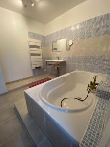 a bath tub in a bathroom with a sink at Les Tilleuls in La Porcherie