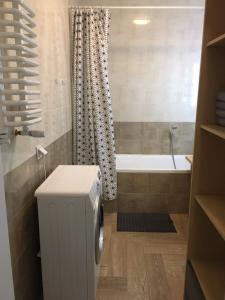 a bathroom with a toilet and a bath tub at Apartament Stanczyka 2 in Warsaw