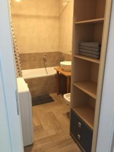 a bathroom with a tub and a toilet and a sink at Apartament Stanczyka 2 in Warsaw