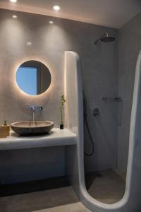 a bathroom with a sink and a shower with a mirror at Blu Rooms Santorini in Akrotiri +76 photos