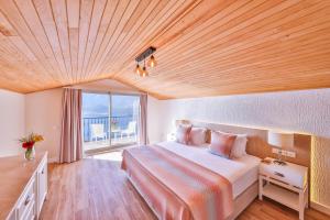 a bedroom with a large bed with a wooden ceiling at Hilaris Hotel in Kas