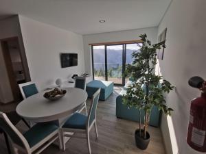 ein Wohnzimmer mit einem Tisch, Stühlen und einer Pflanze in der Unterkunft Casa Miradouro in Cova