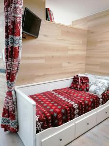 une chambre avec un lit avec une couverture rouge dans l'établissement Le stelle 1400 - Cabanaira Condominio, à Limone Piemonte