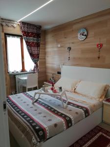 a bedroom with a bed with a table on it at Le stelle 1400 - Cabanaira Condominio in Limone Piemonte