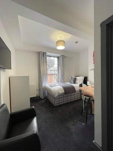 a bedroom with a bed and a desk and a table at Ty'r Bont Studios in Newtown