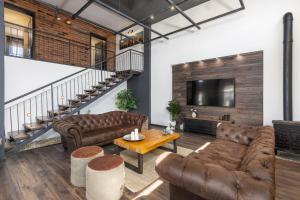 sala de estar con sofás de cuero y TV en Villa stric Toni, en Pakoštane