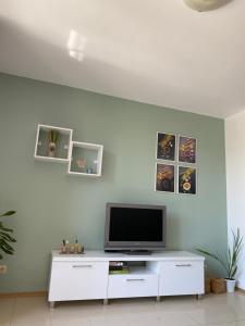 sala de estar con TV en una pared blanca en Villa Poesia, Harmony Hills Residence, en Rogachevo