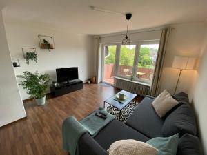 sala de estar con sofá y TV en Moderne Wohnung in stadtnaher, dennoch ruhiger Lage en Nahe