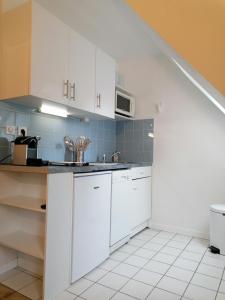 - une cuisine avec des placards blancs et un évier dans l'établissement #Bel appartement cosy Clos Mathilde !, à Cabourg
