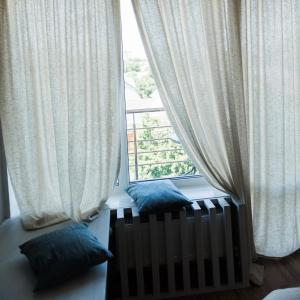 a room with a large window with curtains and pillows at Golden park Apartments in Uman