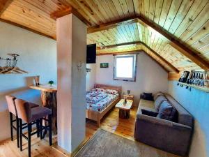 a room with a bed and a couch and a table at Durmitorski konaci apartments in Žabljak