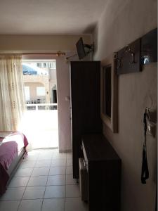 a bedroom with a bed and a door to a window at AZALEA HOTEL in Sarti