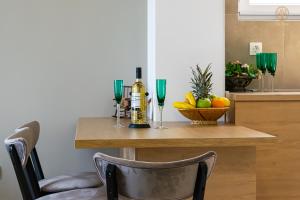 a table with a bottle of wine and a bowl of fruit at La Vita Apartment 2 in Ohrid +5 photos