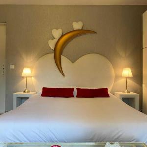 a bedroom with a large bed with two lamps at Domaine de la Palle in Pontgibaud