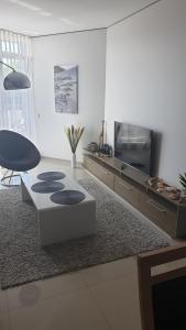 uma sala de estar com uma mesa e uma televisão em Nomuojami apartamentai 600m iki juros em Šventoji