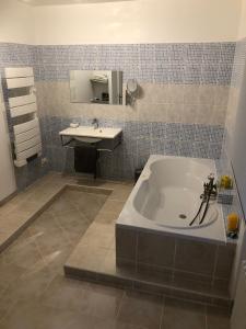 uma casa de banho com uma banheira e um lavatório em Les Tilleuls em La Porcherie