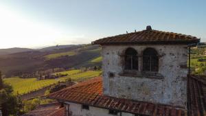 stary budynek z oknem na szczycie wzgórza w obiekcie Villa San Leolino w Greve in Chianti