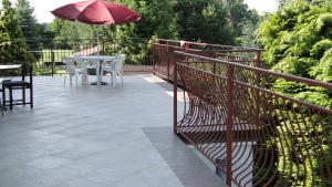 a patio with a table and an umbrella and chairs at Pokoje gościnne U Wandy in Ostrowo