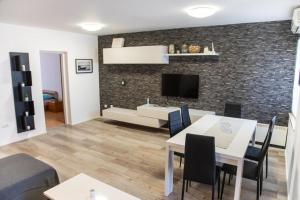 a living room with a table and chairs and a tv at Apartments Jaklin Rovinj in Rovinj