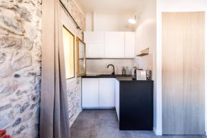 eine Küche mit einer schwarzen Theke und weißen Schränken in der Unterkunft Charming Appartement III in Antibes