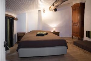 Un dormitorio con una cama grande y un armario de madera. en Location Mas avec Piscine Haut Vallespir, en Le Tech