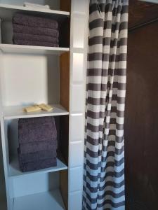 a closet with towels and a shower curtain at Ferienwohnung Auszeit Im Haag in Losheim +12 photos