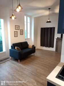 una sala de estar con un sofá azul en una habitación en Joli Appartement avec balcon clim, en Graulhet
