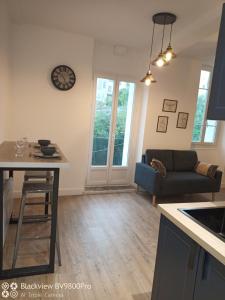 a kitchen and living room with a table and a couch at Joli Appartement avec balcon clim in Graulhet