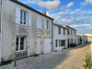 a row of white houses on a cobblestone street at Le Petit Navire in La Flotte