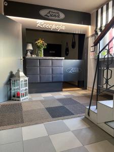 a store lobby with a reception counter and a tile floor at Hotelik Luna in Jarosław