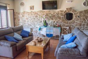 Sala de estar con 2 sofás y mesa en Casa Rural Fuente El Boticario, en Aldeanueva de la Vera