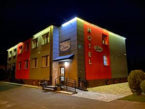 a building that is brightly colored at night at Hotelik Luna in Jarosław