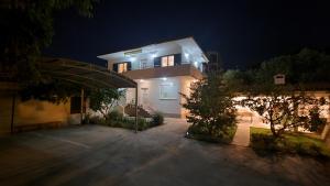 una casa por la noche con las luces encendidas en Apartments Bava, en Trogir