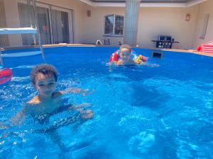 dois rapazes a nadar numa piscina em Suite hôtelière au cœur du Valais em Saxon