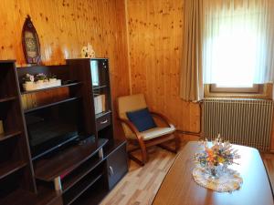 ein Wohnzimmer mit einem TV und einem Tisch in der Unterkunft Apartmani San in Plitvička Jezera