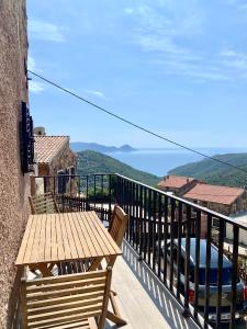 PartinelloSTUDIO TERRASSE VUE MER Clim Wifi Parking的阳台设有木桌,享有海景。