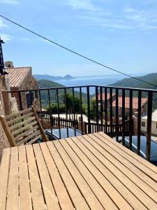 a wooden deck with a bench on a balcony at STUDIO TERRASSE VUE MER Clim Wifi Parking in Partinello