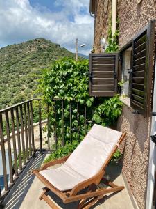 een stoel op een balkon met uitzicht op een berg bij STUDIO TERRASSE VUE MER Clim Wifi Parking in Partinello
